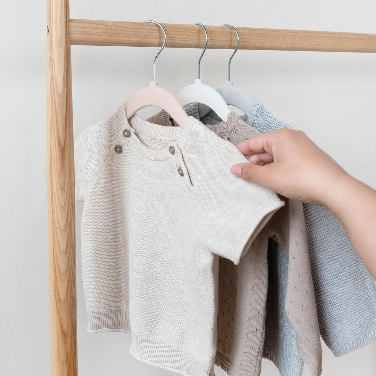 Nordic cream, grey, and hazelnut hangers blend with nursery décor