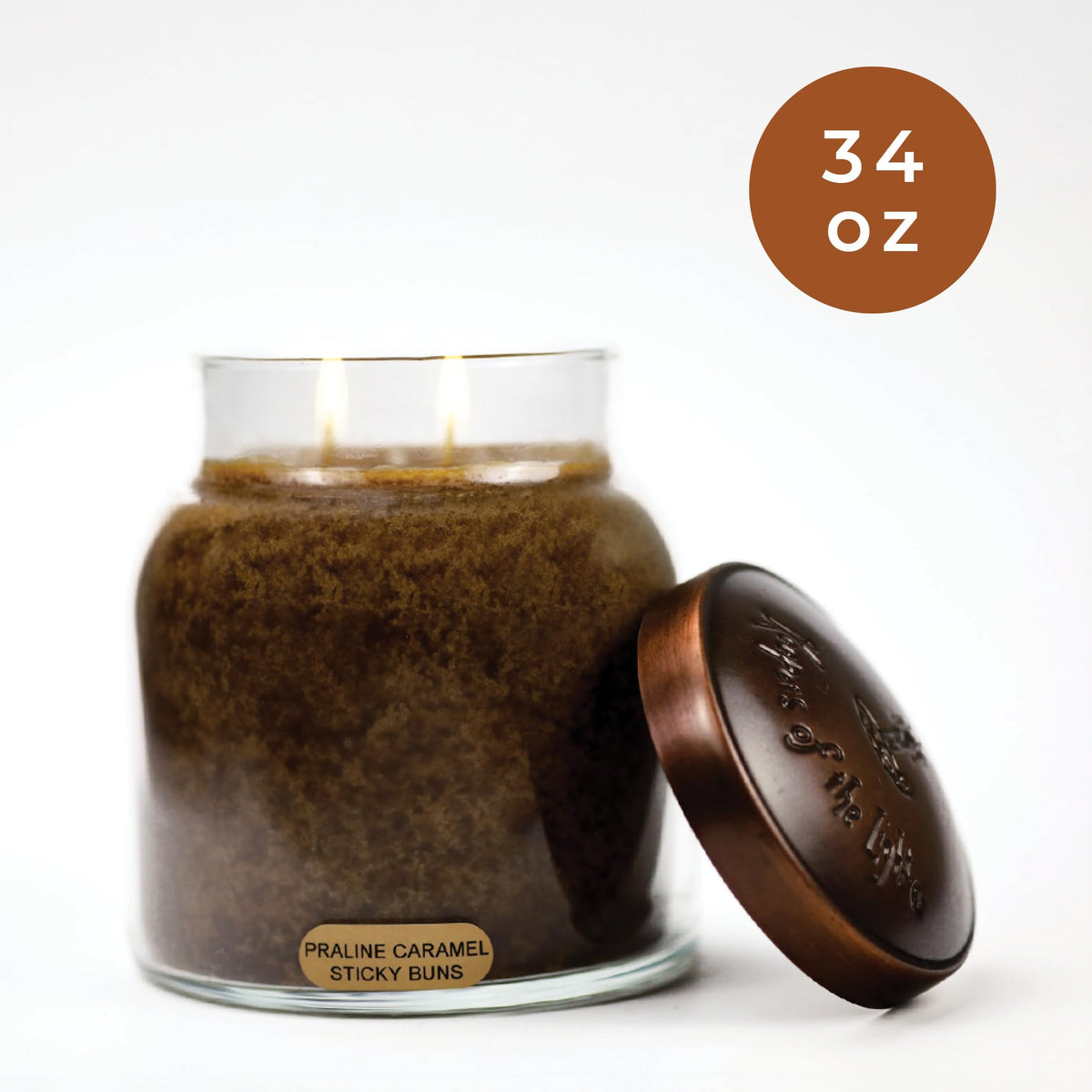 A warm glow from the Praline Caramel Sticky Buns candle enhances mood.