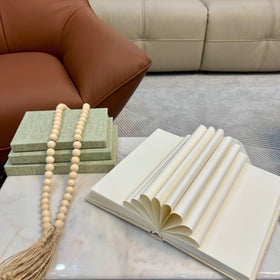 ADUN Stationery linen covered books stacked on coffee table spotlight chic minimalism.