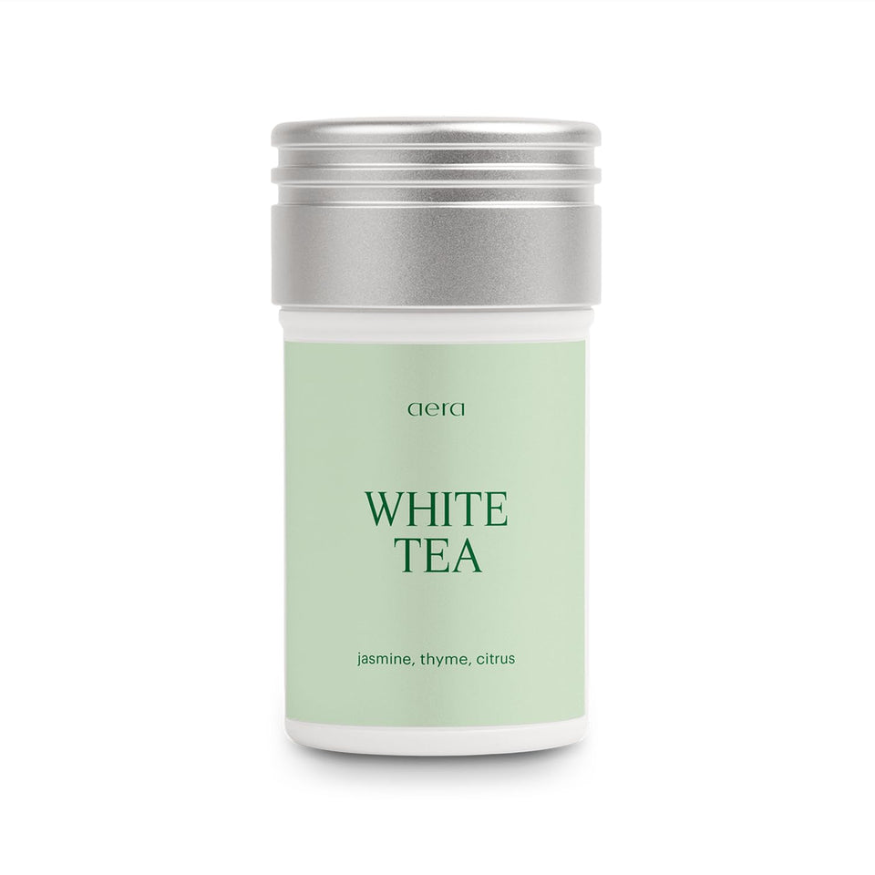 Aera White Tea refill bottle pouring, creating a calm living room ambience.