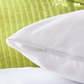 AllerEase pillow protector on a bed illustrates simple layering for better sleep.