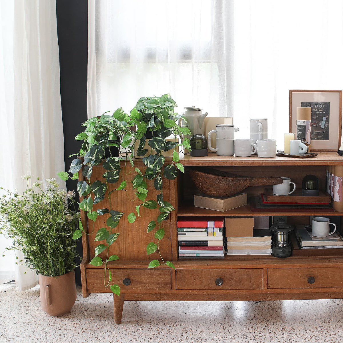 Alyptus vines draped over a window sill provide a low-maintenance greenery look.