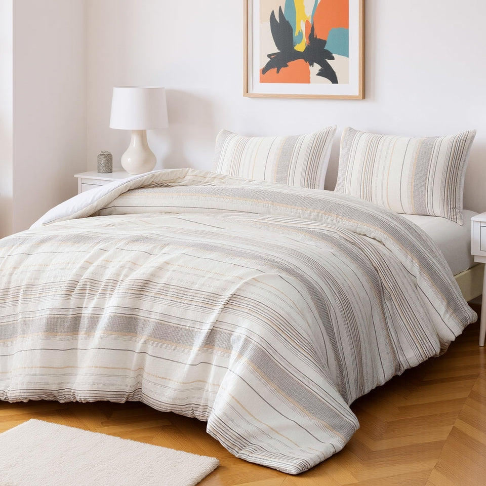 Amazon Basics comforter set on bed with beige stripes provides versatile all-season warmth.
