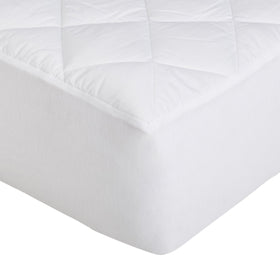Amazon Basics hypoallergenic quilted topper on a bed setup shows cozy and breathable comfort