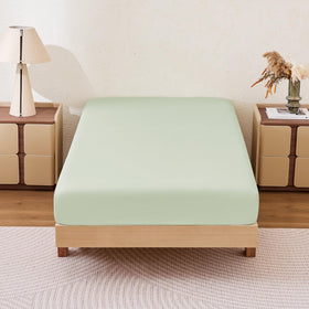 Amazon Basics Aloe Green queen fitted sheet on bed, soft microfiber feel and two-pack convenience.