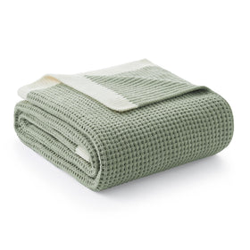 Amélie Home chenille throw with ultra-soft finish draped on a couch for cozy lounging.