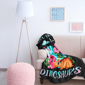 Amonee-YL dinosaur blanket used as a travel rug in a car setting.