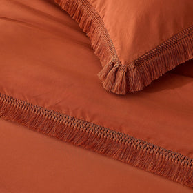 Bedroom scene featuring Andency bed setup with burnt orange comforter.