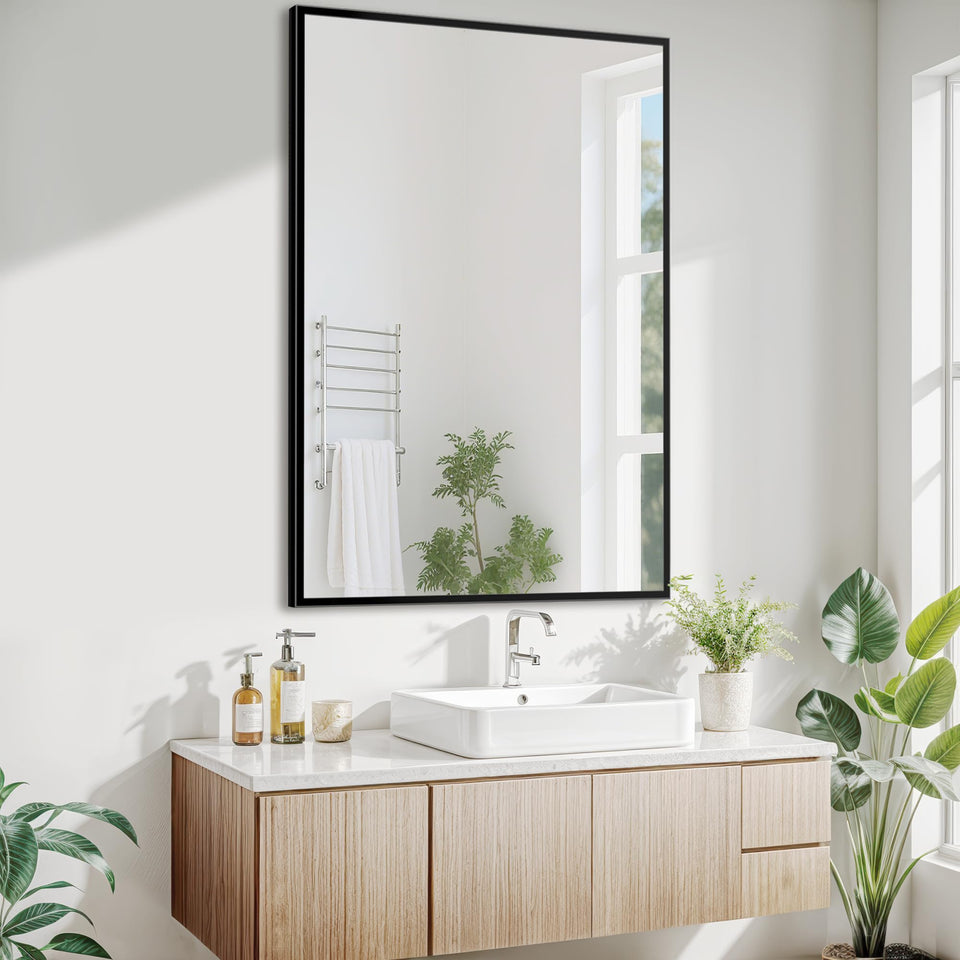 Antok 24x36 black metal framed bathroom mirror above a sink for a modern look.