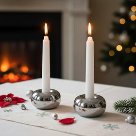 Ardax silver doughnut candlestick holder on living room table, reflective finish.