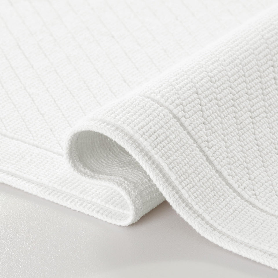 Arkwright 100% cotton bath rug with textured weave for soft, absorbent bathroom floors.