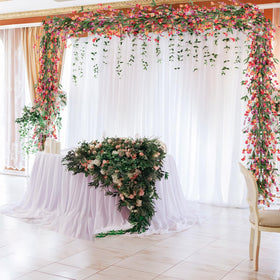 Artgar garland on a wedding arch creates a romantic photo backdrop.