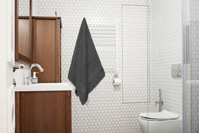 ASTILTEX charcoal grey towel drying after shower, highlighting plush texture.