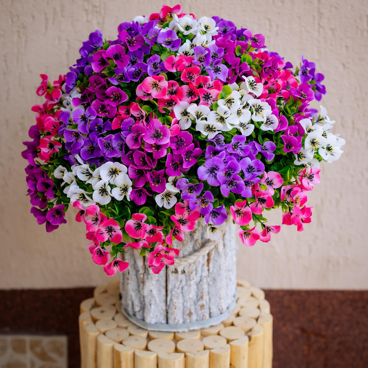 AXYLEX faux pansy plants decorate a garden corner with lush color.