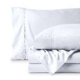 Bare Home bedroom scene with cozy white sheets for a calm retreat.