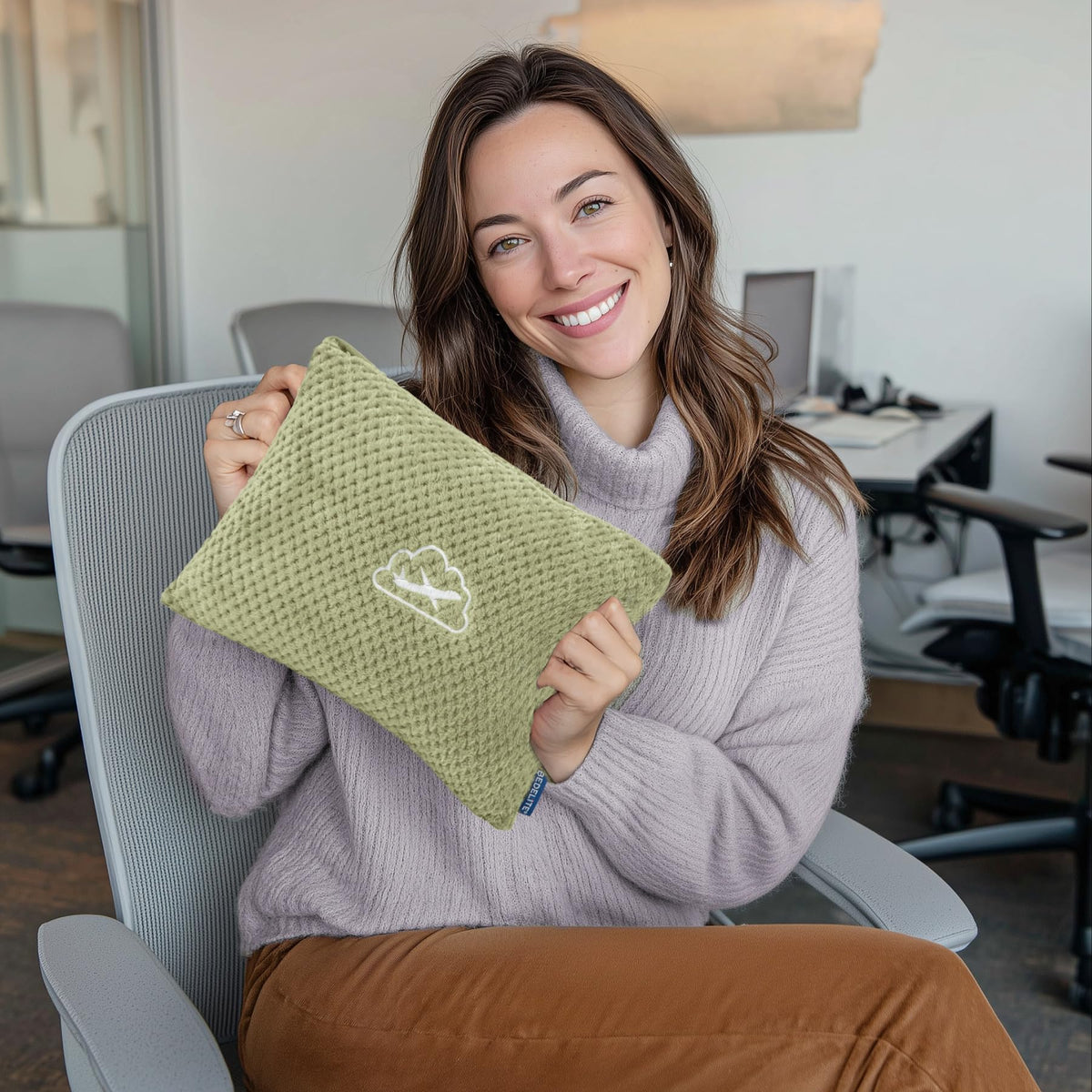 BEDELITE blanket with metal clip attached to a backpack for hands-free travel.
