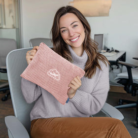 BEDELITE pink travel blanket beside luggage sleeve for hands-free travel.