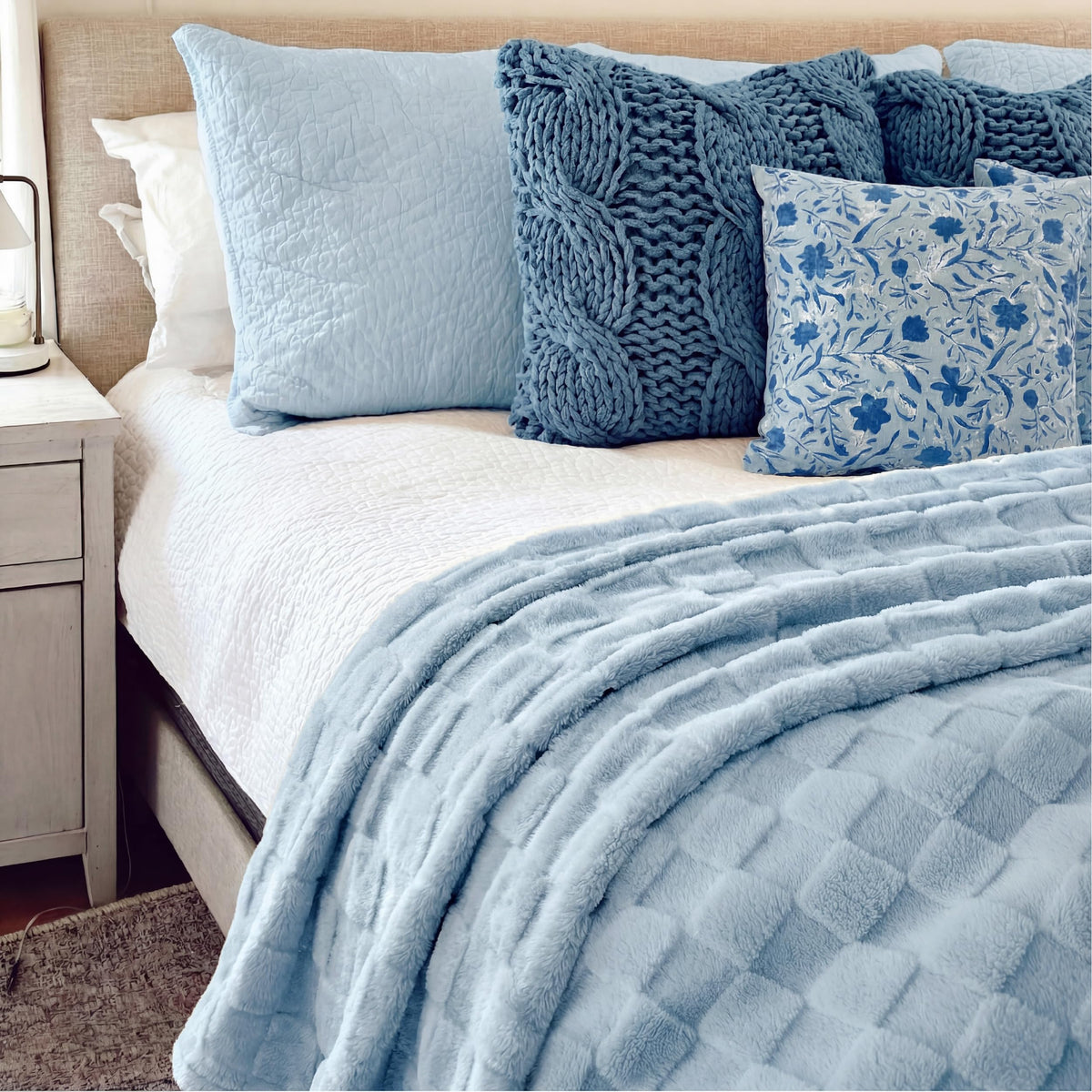 Bedsure GentleSoft baby blue throw on bed beside pillow enhances bedtime comfort.