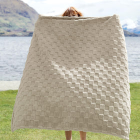 Bedsure GentleSoft beige throw with checkered pattern adds warmth to sofa.