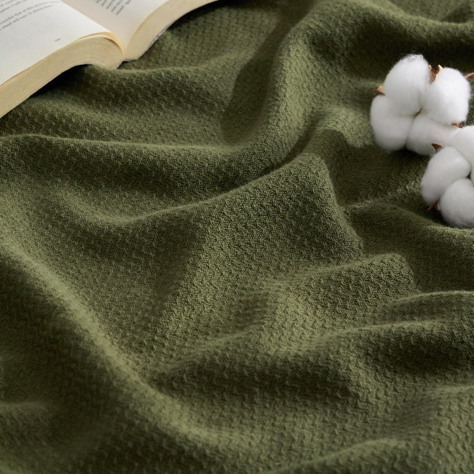 Bedsure GentleSoft olive green blanket folded on a dorm bed for comfort.