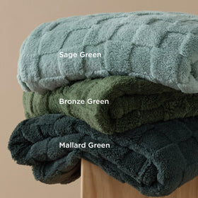 Bedsure GentleSoft Bronze Green Throw Blanket in a dorm room setup