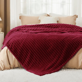 Bedsure GentleSoft Deep Red Blanket folded on sofa for plush comfort.