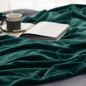 Bedsure emerald green blanket draped over a chair for everyday lounging.
