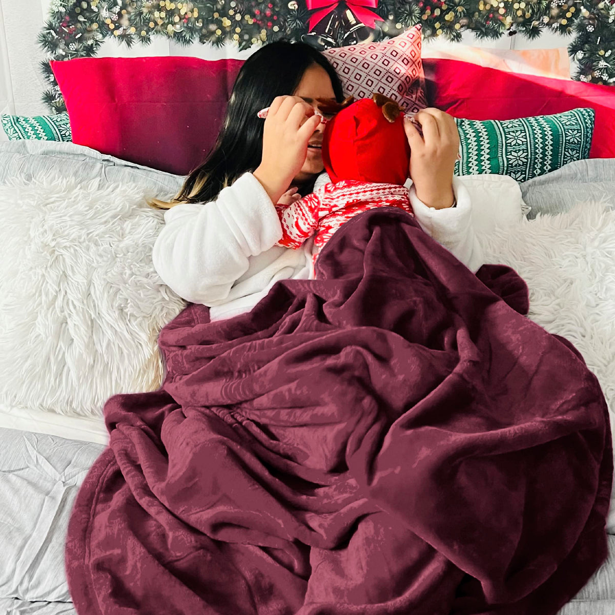 Bedsure GentleSoft fleece blanket draped with decorative pillows for a warm room look.