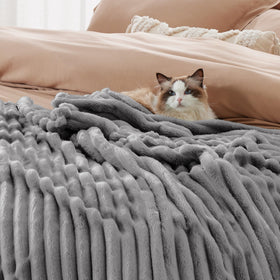 Bedsure GentleSoft Frost Gray blanket draped over an armchair for inviting coziness.