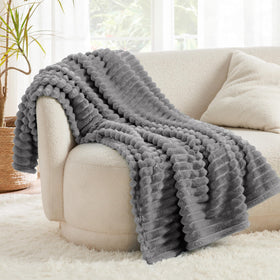Bedsure GentleSoft Frost Gray blanket piled on bed with striped pattern for cozy decor