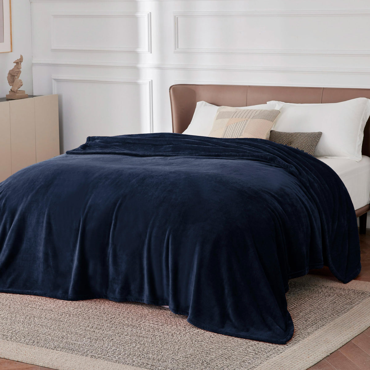 Bedsure GentleSoft navy fleece blanket on a nightstand, lightweight and comforting