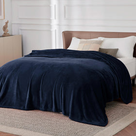 Bedsure GentleSoft navy fleece blanket on a nightstand, lightweight and comforting