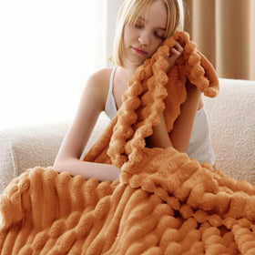 Bedsure GentleSoft orange fall throw blanket on couch for cozy movie nights.