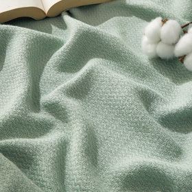Bedsure GentleSoft sage-green throw on a couch for relaxed summer comfort.