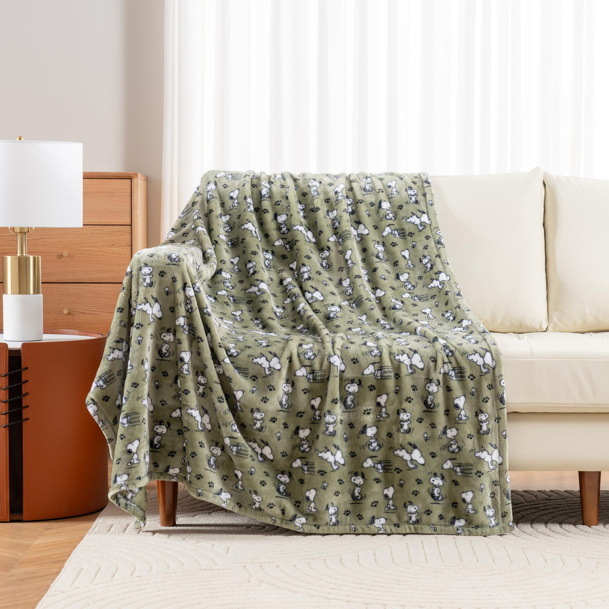 Berkshire Blanket Peanuts VelvetLoft throw featuring Snoopy on a sofa.