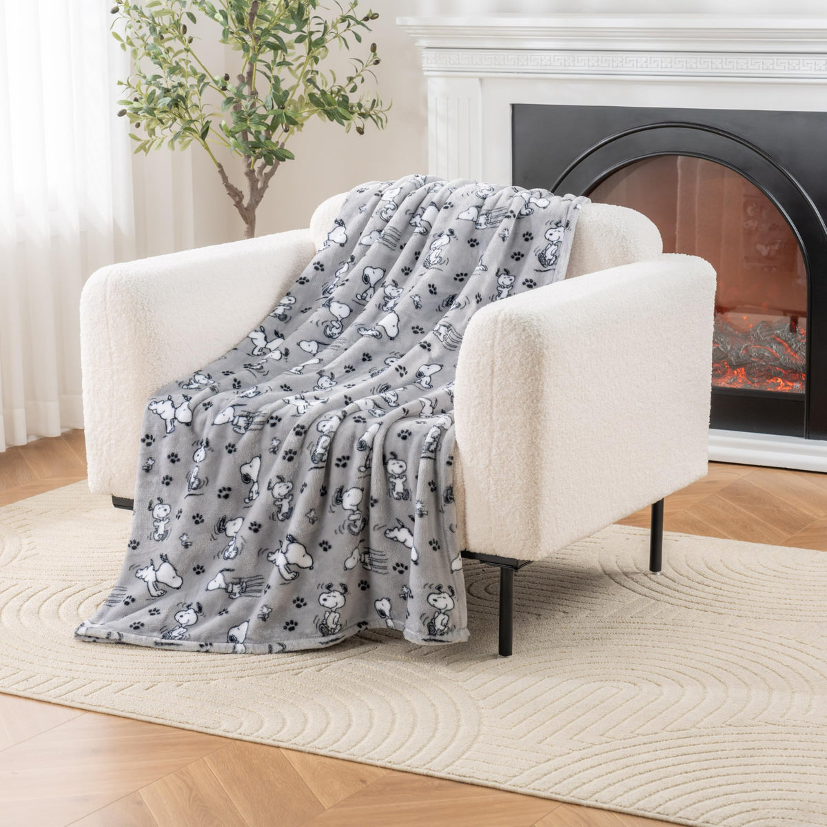 Berkshire Blanket Peanuts VelvetLoft Snoopy plush throw on couch for cozy warmth.