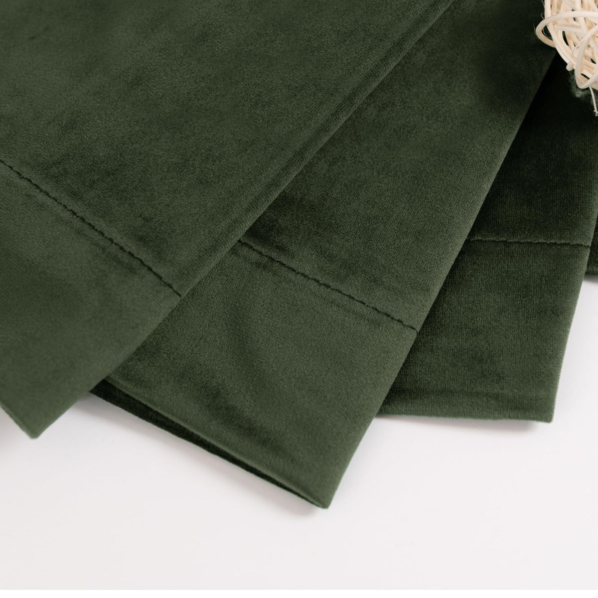 Back tab and rod pocket detail on olive velvet curtains, versatile hanging options.