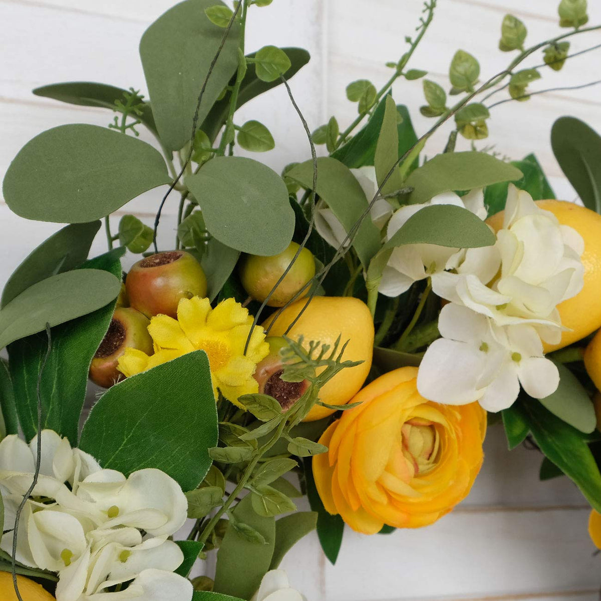 Bibelot lemon wreath enhances festive front-door display and party ambiance.