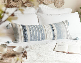 BlissBlush bed and lounge decor features coastal blue lumbar cover.