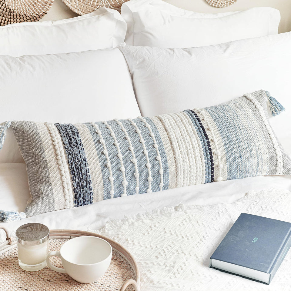 BlissBlush coastal blue lumbar pillow cover on bed adds relaxed coastal style.