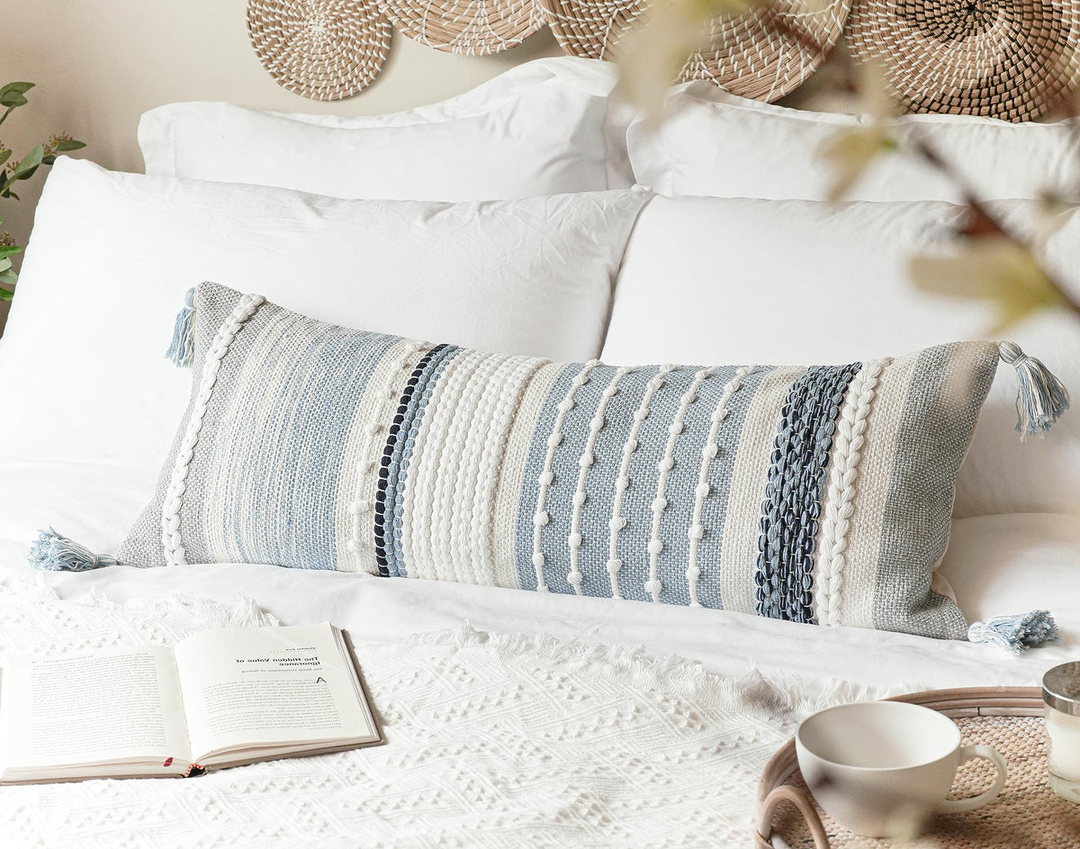 BlissBlush coastal blue pillow on bed creates cozy retreat.
