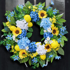Bloeien 24in wreath with sunflowers, lemons, and blue hydrangeas for a vibrant front door.