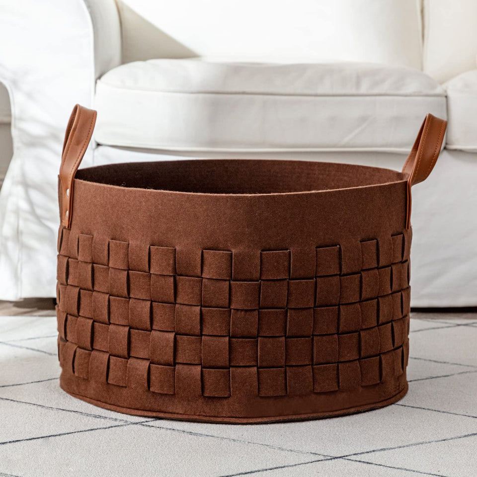 BoldMonkey laundry basket with leather handles holds blankets safely in living room.
