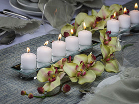 Bolsius white pillar candle 2x3 on dining table creates warm ambience.