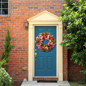 Brown twig-vine base supports BOMAROLAN wreath design
