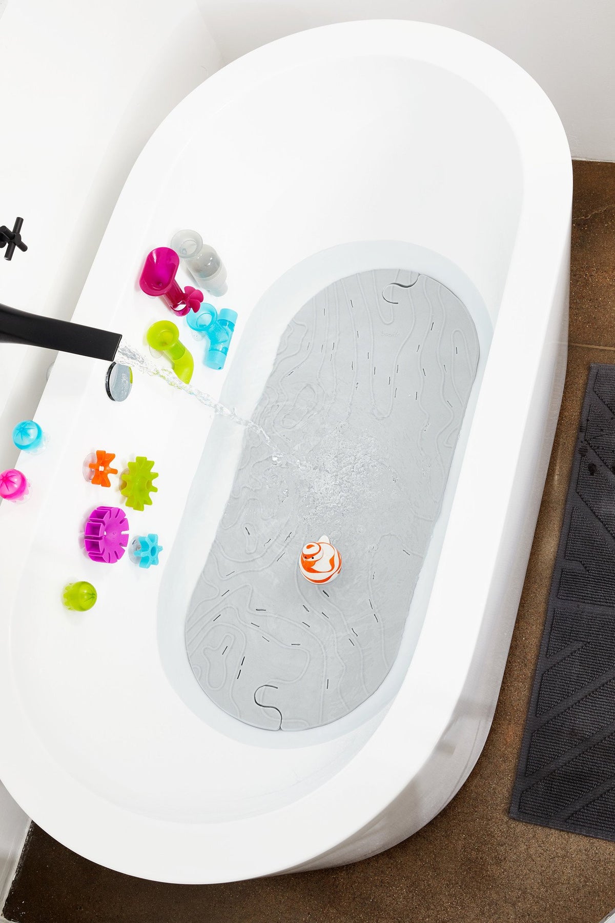 Boon Griffle mat in use inside a smooth tub during a baby bath