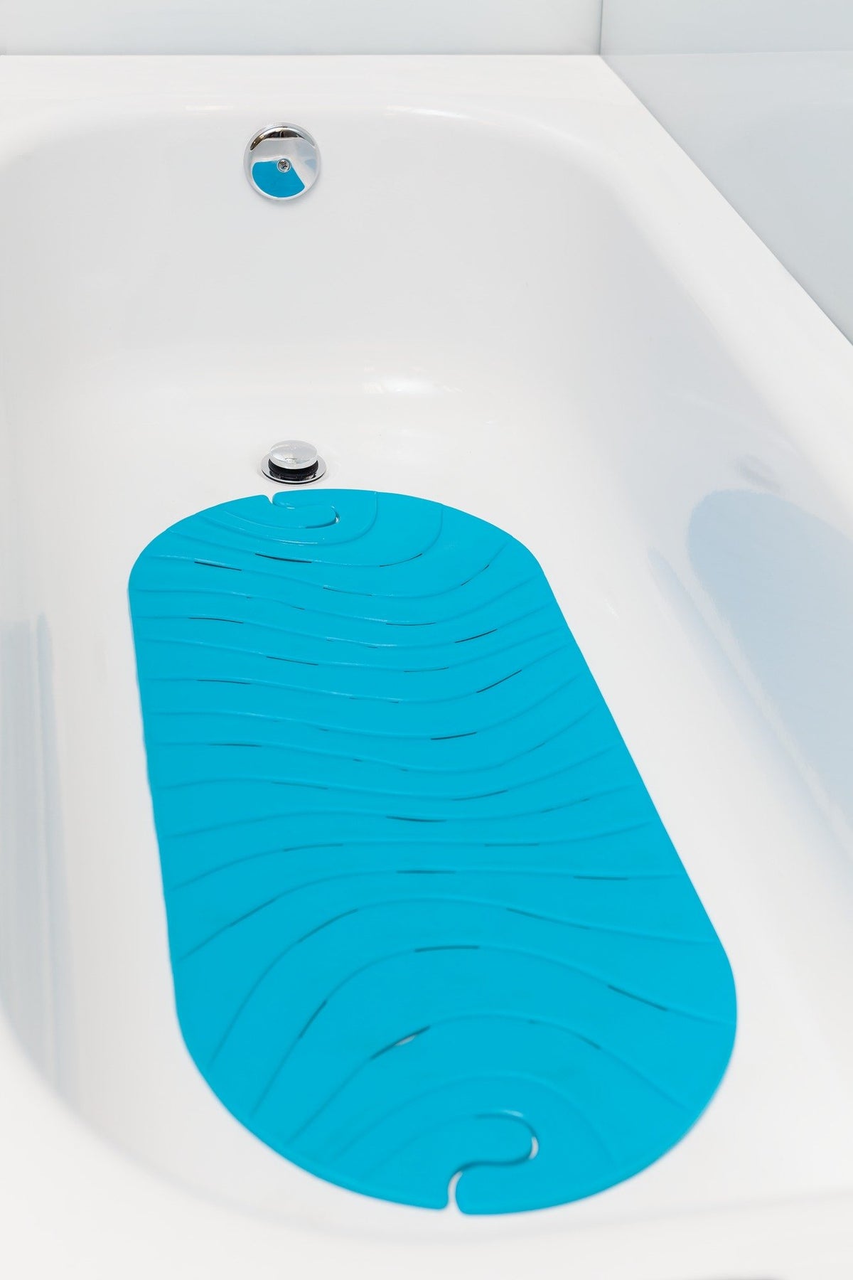Boon Ripple bath mat with drain holes to reduce water buildup after baths.