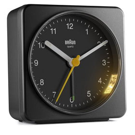 Braun bedside alarm clock on a nightstand ready for routine wakeups.
