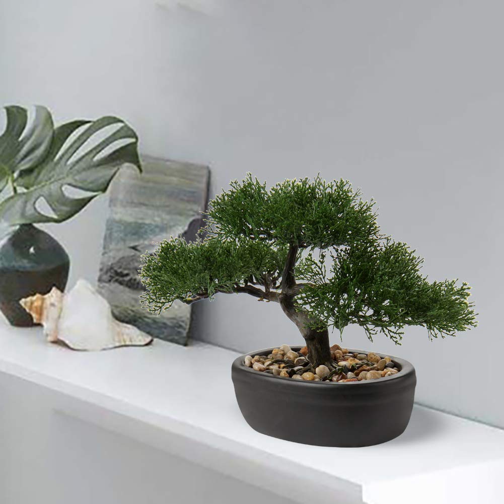 Briful artificial bonsai juniper on a desk adds tranquil greenery.
