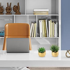 Briful artificial plants in gold pots brighten a bathroom shelf with charm